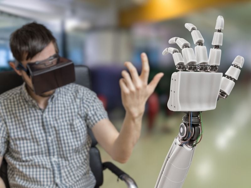 Ingeniero en mecatrónica probando brazo robótico con realidad virtual