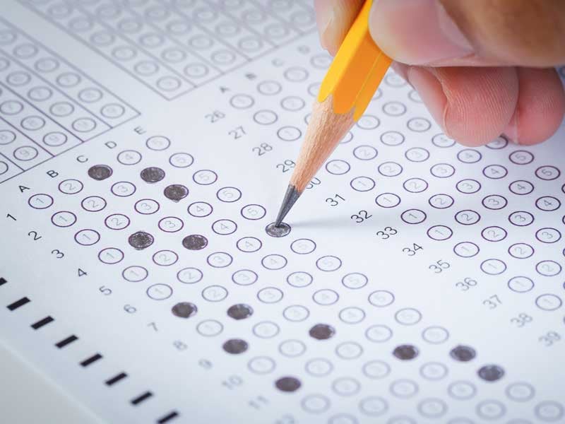 Hoja de respuestas del examen de admisión UNAM 2025 siendo llenada con lápiz.