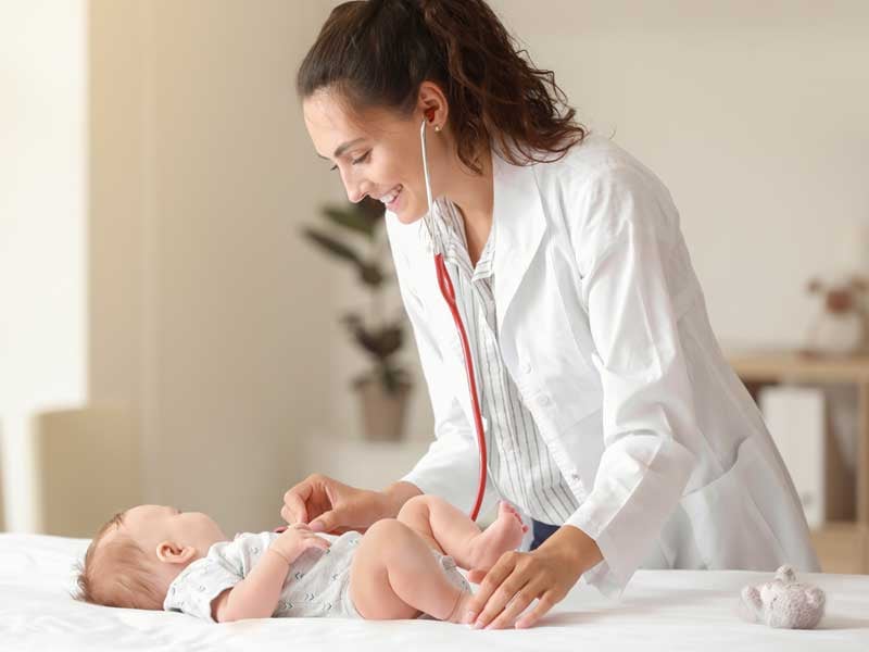 Médico atendiendo a un bebé, representando la práctica de especialidades médicas como pediatría y cuidado de la salud infantil.