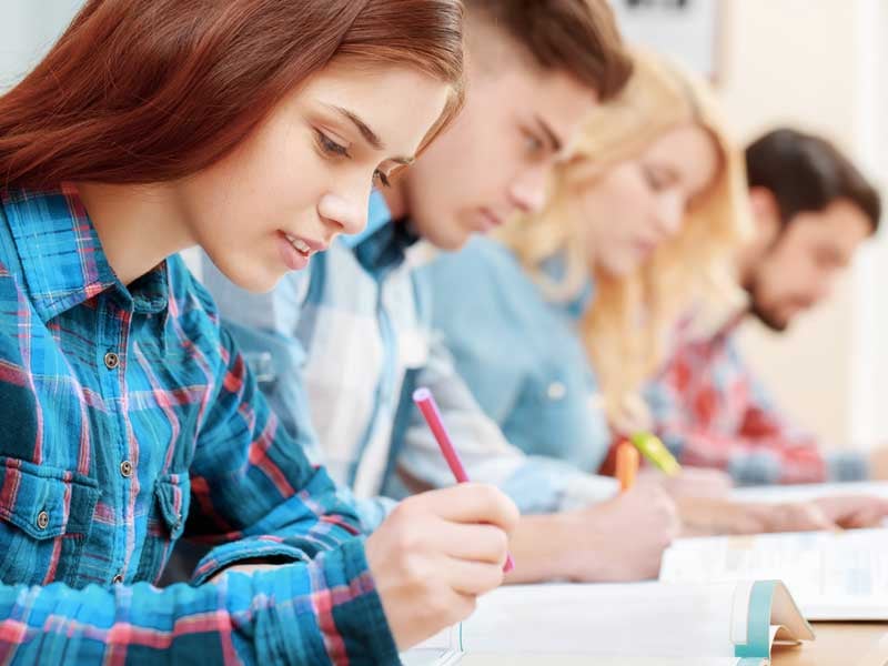 Grupo de estudiantes resolviendo ejercicios durante el examen de ingreso a la UNAM 2025.