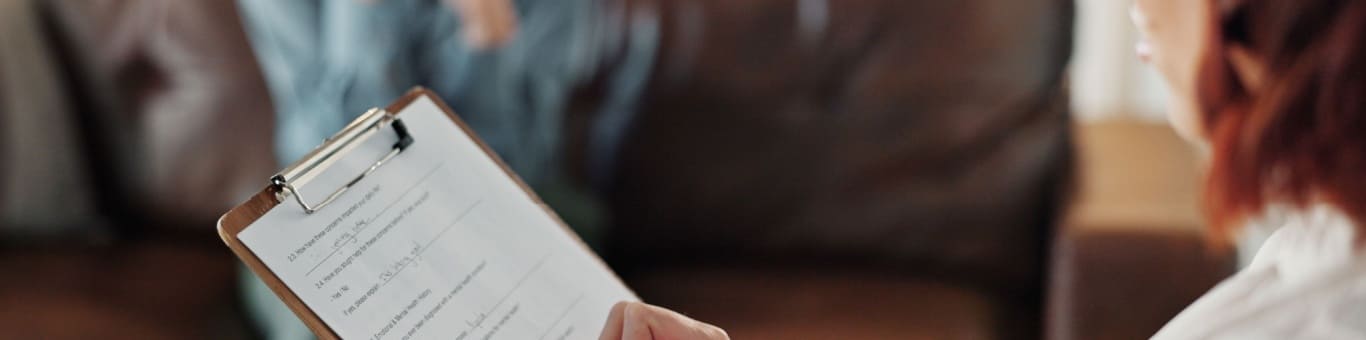 psicólogo realizando evaluación psicológica con formulario durante sesión de consulta