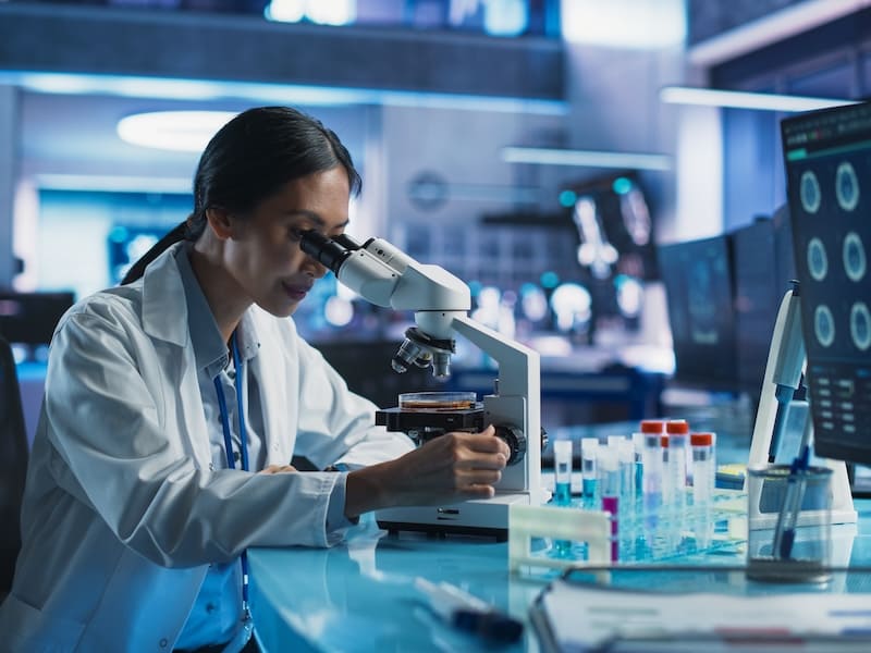 Mujer cientifica viendo un microscopio