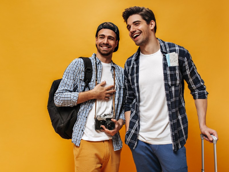 estudiar-turismo-hospitalidad-jovenes-viajeros-muestran-camara-y-maletas