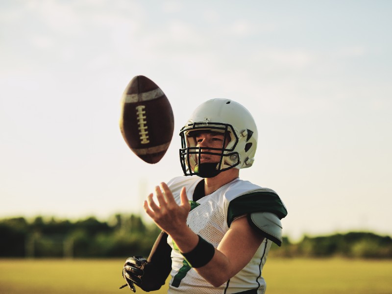 becas-deportivas-joven-sostiene-balon-de-americano