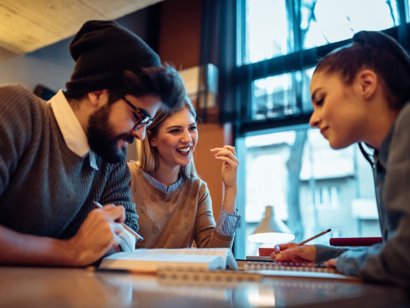 como-estudiar-con-beca-jovenes-estudian-en-una-mesa