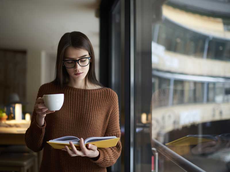 Mujer ejecutiva leyendo un libro para actualizar sus conocimientos