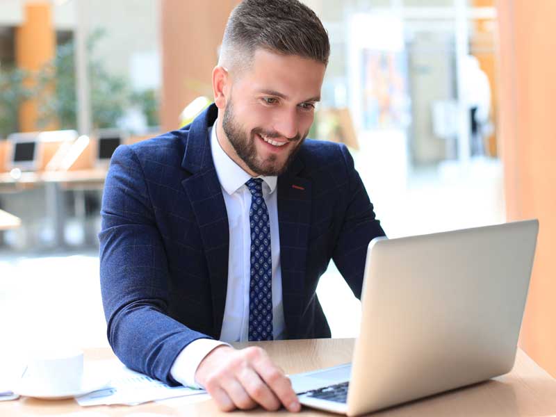 Joven ejecutivo tomando curso de inglés en su computadora