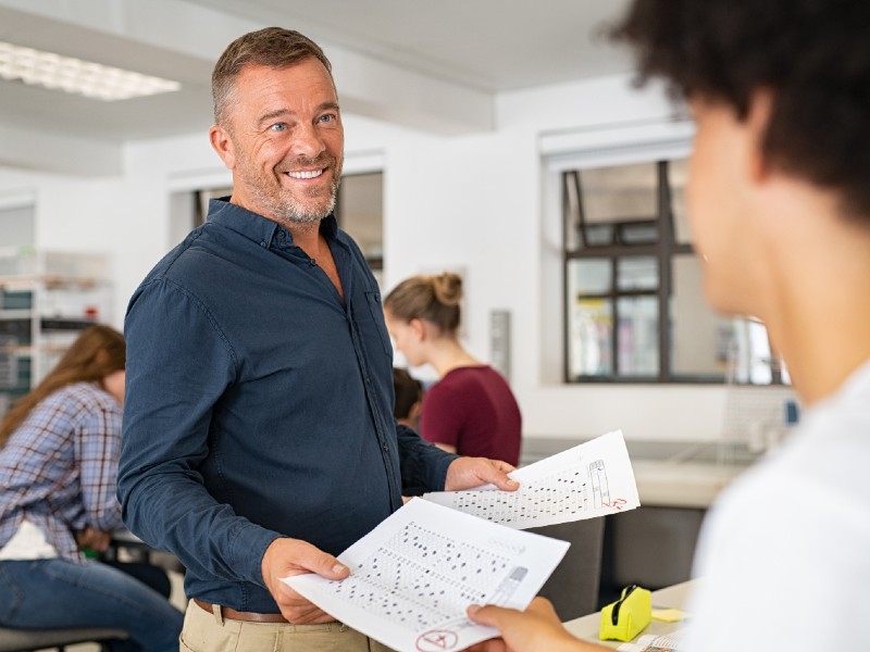 estudiar-con-beca-profesor-entrega-resultado-a-alumno